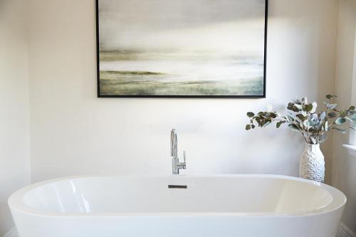 a white bath tub in a bathroom with a painting at Milliken Creek Inn in Napa