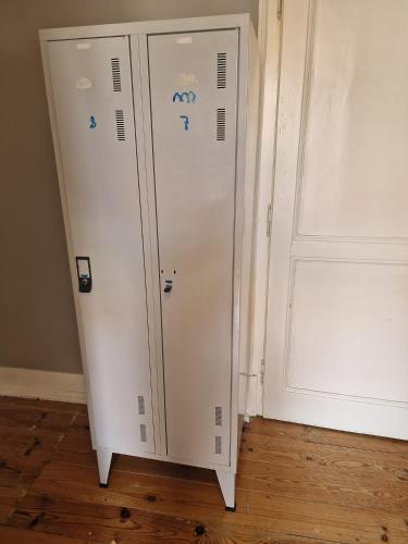 a white cabinet with stickers on it next to a door at D&N Hospedagem Lisboa in Lisbon