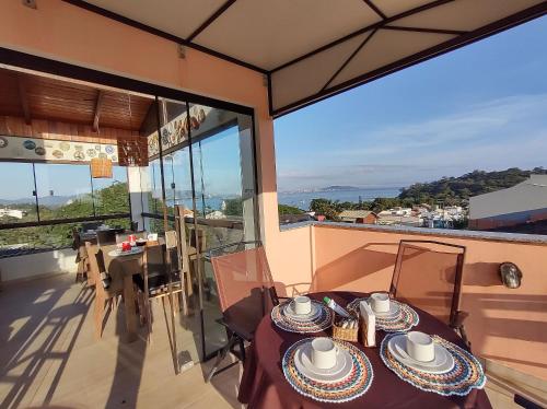 a table on the balcony of a house at Casa da Flôr GuestHouse, Praia Grande, Beto Carrero in Penha