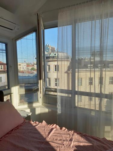 a bedroom with a large window with a view of a building at Perla 2 studio in Burgas City