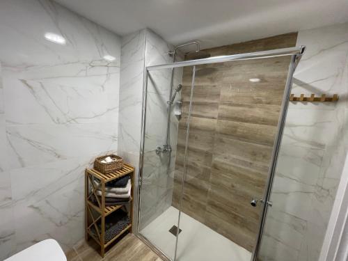 La salle de bains est pourvue d'une cabine de douche et de murs en marbre blanc. dans l'établissement Apartamento in Cullera. Spain, à Cullera