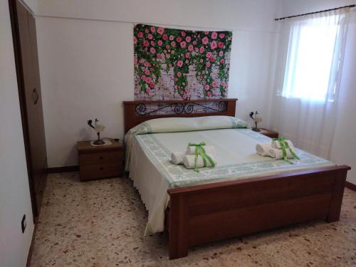 een kleine slaapkamer met een bed met een bloemrijk hoofdeinde bij Belvedere in Pantelleria