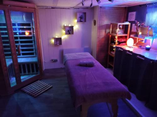 een kleine kamer met een paarse tafel en een raam bij La chambre secrète in Longueval