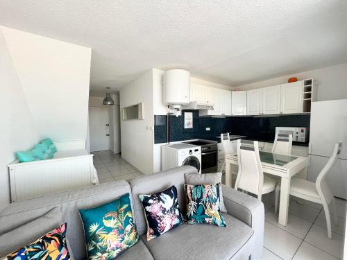 un salon avec un canapé et une cuisine dans l'établissement BARCARESA-Elégant appartement vue mer wifi parking, au Barcarès