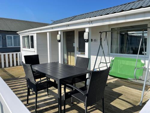 a black table and chairs on a deck with a caravan at Seabirds - 3 bed chalet, dog friendly, Bridlington in Bridlington