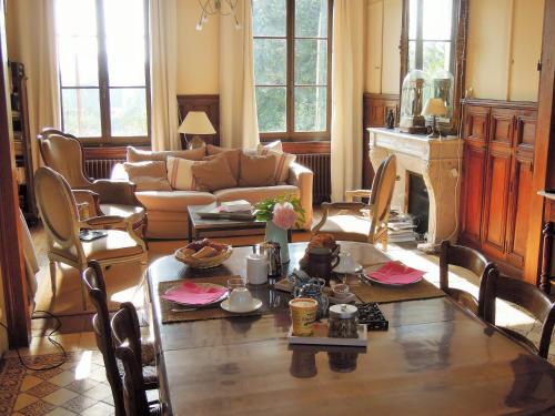 ein Wohnzimmer mit einem Tisch und einem Sofa in der Unterkunft Clos Florésine B&B in Margny-lès-Compiègne