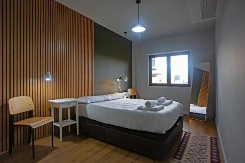 a bedroom with a bed and a table and a chair at Luxury apartment near Fonte Luminosa in Lisbon