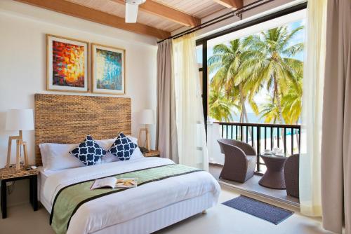 een slaapkamer met een bed en een balkon met uitzicht bij Crystal Sands in Maafushi
