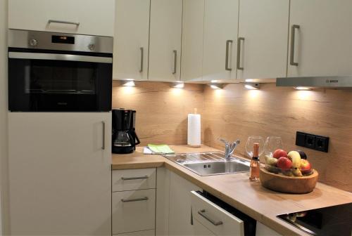 a kitchen with a sink and a bowl of fruit on a counter at Ferienwohnung Bergflora in Oberstdorf