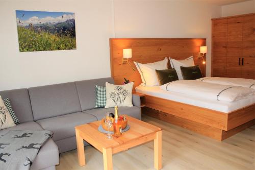 ein Hotelzimmer mit einem Bett und einem Sofa in der Unterkunft Ferienwohnung Bergflora in Oberstdorf