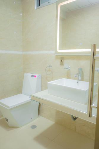 a bathroom with a sink and a toilet and a mirror at R&N SHULLKAS SUITES in Huancayo