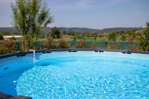 une grande piscine avec de l'eau bleue dans l'établissement MAISON PROVENÇALE calme et ensoleillée, à Saint-Gervais