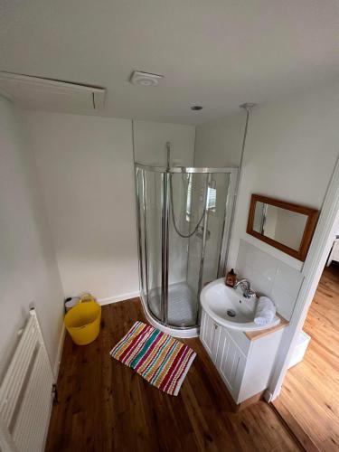 ein Bad mit einer Dusche und einem Waschbecken in der Unterkunft Glen Nevis Place in Inverlochy