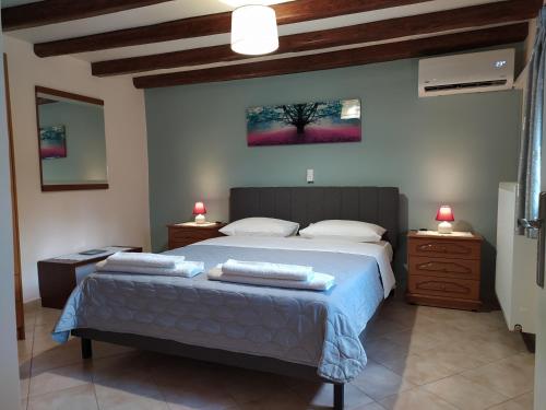 um quarto com uma cama grande e duas mesas de cabeceira em Olive Grove Rooms em Kalabaka
