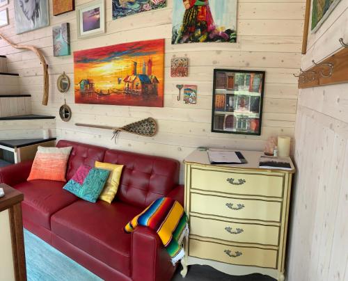 a living room with a red couch and a desk at Cliffside Hideaways 