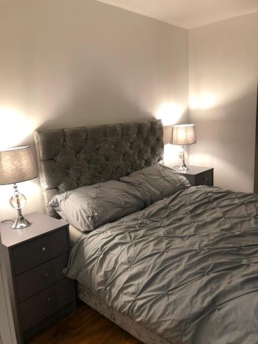 a bedroom with a bed with two nightstands and two lamps at Exclusive Modern decorated 1 Bedroom Detached Studio in Newport