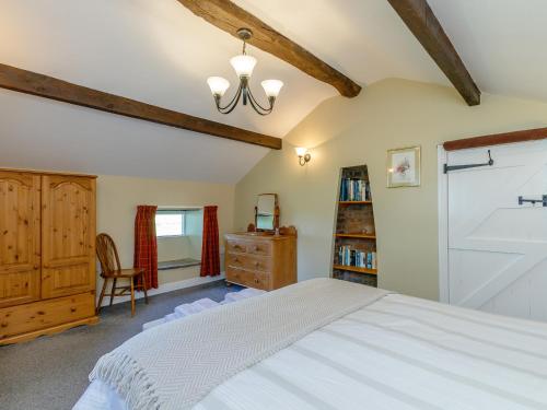 Golden Slack Cottage في Allgreave: غرفة نوم بسرير ومكتب وكرسي
