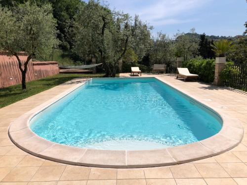 a swimming pool in a yard with a patio and trees at Villino con piscina in Terni