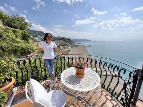 a woman standing on a balcony overlooking the water at Due Relais - Panoramic Sea View Suites in Vietri