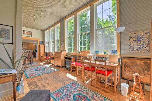 a room with a table and chairs and windows at Bright Converted Schoolhouse in Chesterfield! in Chesterfield