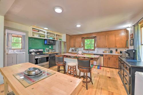 a large kitchen with wooden cabinets and a wooden table at Bright Converted Schoolhouse in Chesterfield! in Chesterfield
