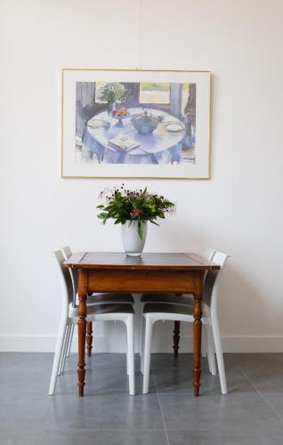 a table with a vase of flowers on top of it at Gastenverblijf De Oare Keamer Kollum Friesland in Kollum
