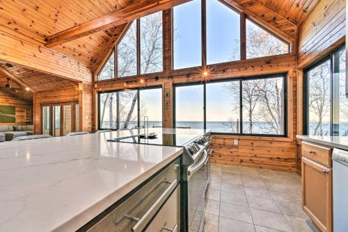 a kitchen with a large counter top and windows at Lakefront Applegate Retreat with Private Beach! in Applegate