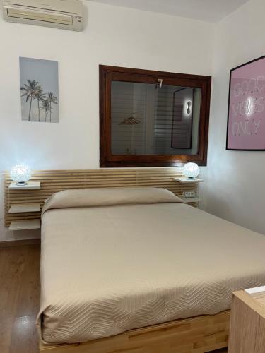 a bedroom with a large bed with a window at MiCasaEsTuCasa in Porto Santo Stefano
