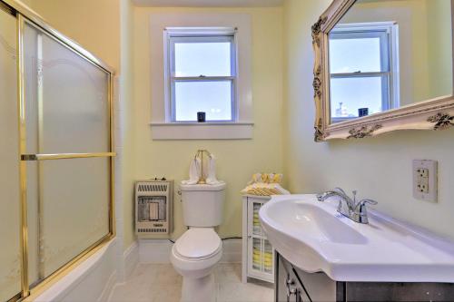 a bathroom with a toilet and a sink and a mirror at Spacious Lanett Haven with Sunroom and Large Deck in Lanett