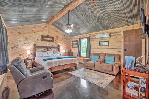 Updated Studio Cabin in Ozark - Mountain View في Ozark: غرفة نوم كابينة خشب بها سرير وأريكة