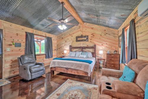 a bedroom with a bed and a chair in a room at Updated Studio Cabin in Ozark with Yard and Mtn View in Ozark