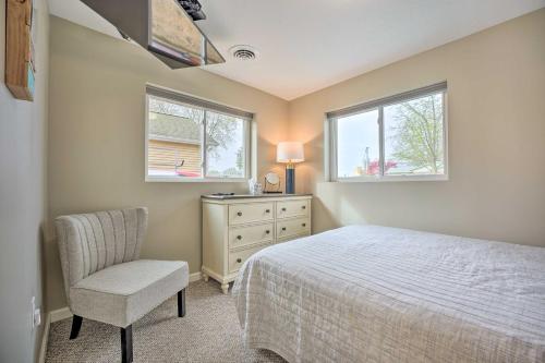 a bedroom with a bed and a chair and two windows at Waterfront Syracuse Home with Patio and Fire Pit! in Syracuse