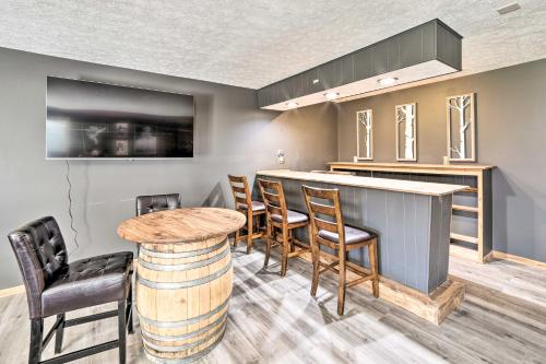 a kitchen with a bar with chairs and a table at Spacious Getaway with Heated Private Pool! in Michigan City