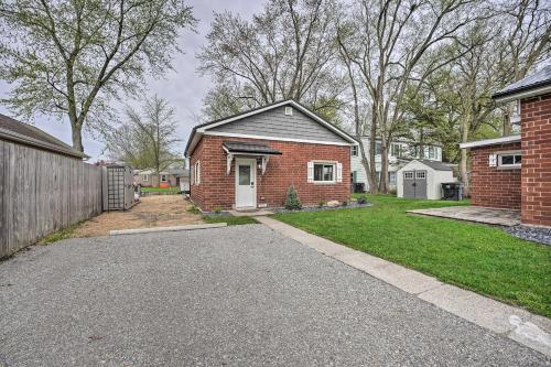 a brick house with a driveway in a yard at Waterfront Syracuse Home with Patio and Fire Pit! in Syracuse