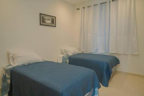 two beds in a room with a window at Camino al Mar a pie de playa in Mazatlán
