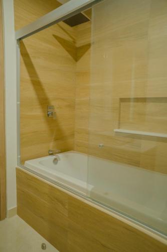 a bathroom with a bath tub with a glass wall at Camino al Mar a pie de playa in Mazatlán