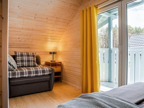 a room with a bed and a window with yellow curtains at Diune Resort at the seashore in Miedzywodzie for 7 persons in Międzywodzie