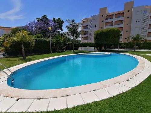 een groot blauw zwembad in een tuin bij Happy Dreams Mar Salgado in Armação de Pêra