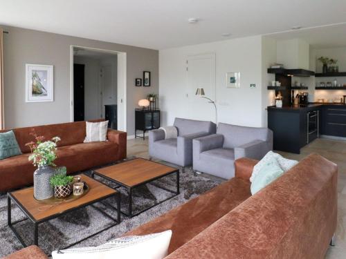 ein Wohnzimmer mit Sofas und einem Tisch in der Unterkunft Villa in Friesland with Sauna and Jetty in Delfstrahuizen