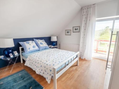 a bedroom with a bed and a window at Luxurious holiday home with a nice private garden in Ditscheid