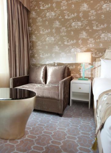a living room with a couch and a bed at Dorsett Shepherds Bush London in London