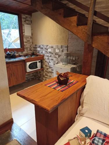 a kitchen with a wooden counter with a bowl of fruit on it at CHALÉS LUAR DO PICO in Santo Antônio do Pinhal