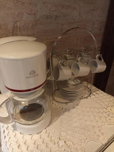a coffee maker sitting on top of a table at CHALÉS LUAR DO PICO in Santo Antônio do Pinhal