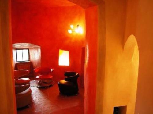Habitación con paredes y sillas rojas y pasillo. en La Torre di Cetona, en Cetona
