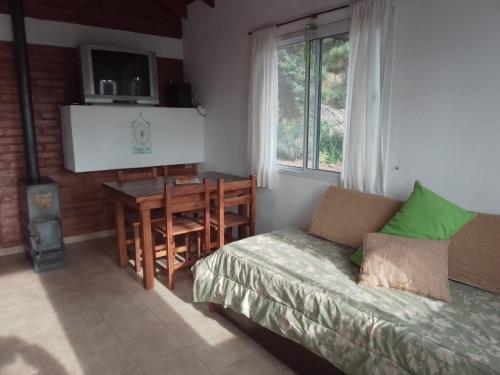 1 dormitorio con cama, mesa y escritorio en Espejo de Hadas - Terrafirme, en Villa Yacanto