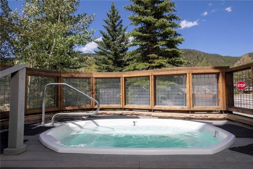 ein Whirlpool auf einer Terrasse mit Zaun in der Unterkunft Three-Bedroom Apartment in Keystone