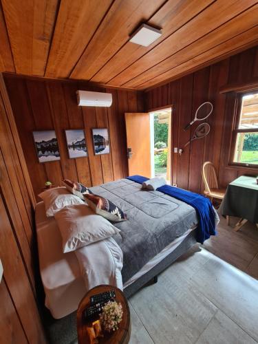 a bedroom with a bed in a wooden wall at Empório reserva da serra com área lazer natureza e excelente localização in Campos do Jordão