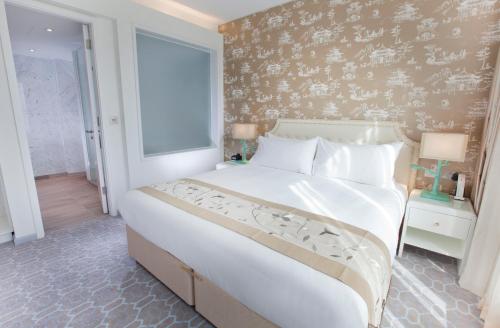 a bedroom with a large white bed and a window at Dorsett Shepherds Bush London in London