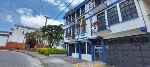 ein blau-weißes Gebäude an der Straßenseite in der Unterkunft Hotel La Castellana in Manizales