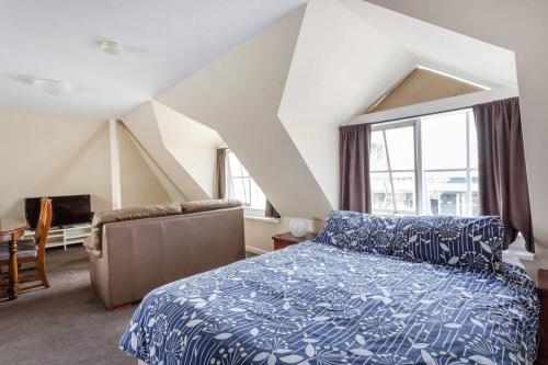 1 dormitorio con cama, sofá y ventana en Upstairs Studio Apartment with street access en Melbourne